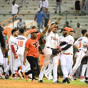 Jugadores de los Toros del Este celebran en el terreno tras la victoria frente a los Tigres del Licey en el primer partido de la doble cartelera.
